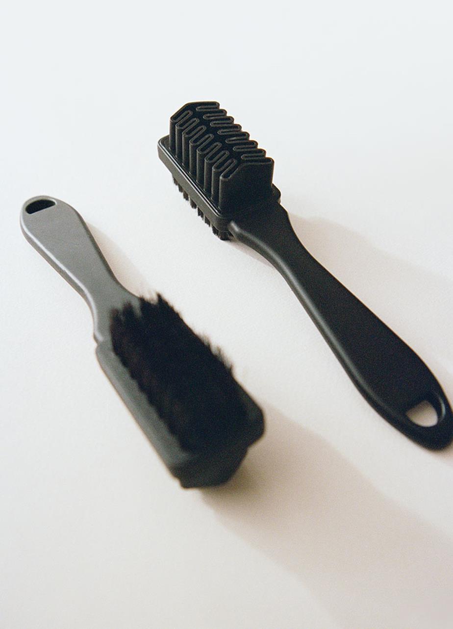 Två svarta nubuckborstar på ljus bakgrund