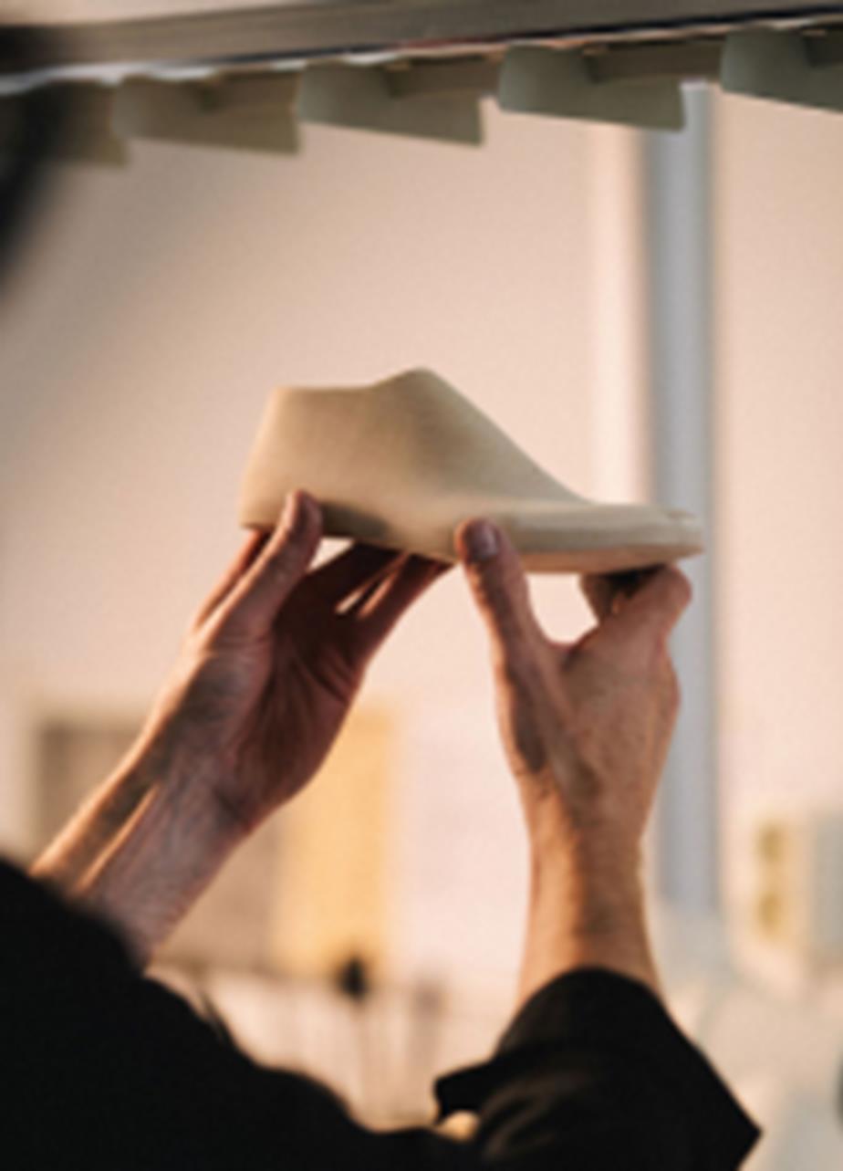 Wooden shoe last held up by two hands