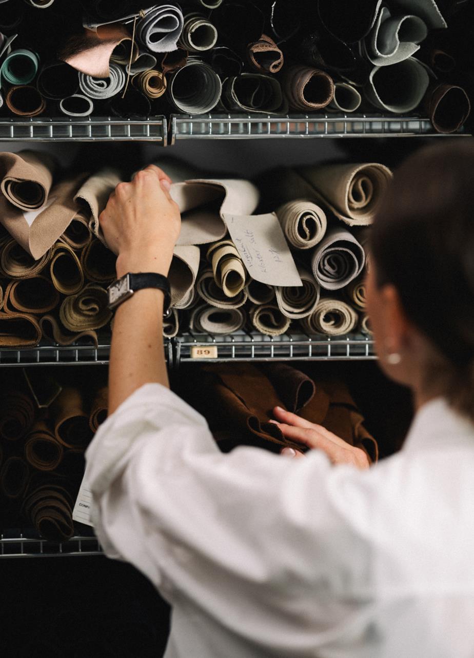 Designer selecting rolls of fabric and leather in a material archive
