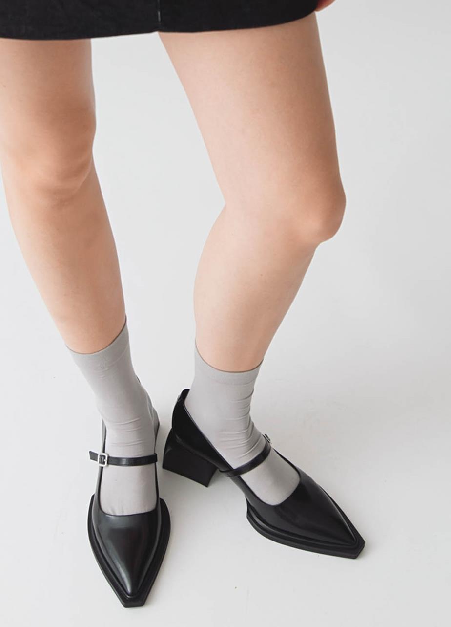 Heeled Vivan Mary Jane shoes, in polished leather with pointed toes, styled with grey socks.