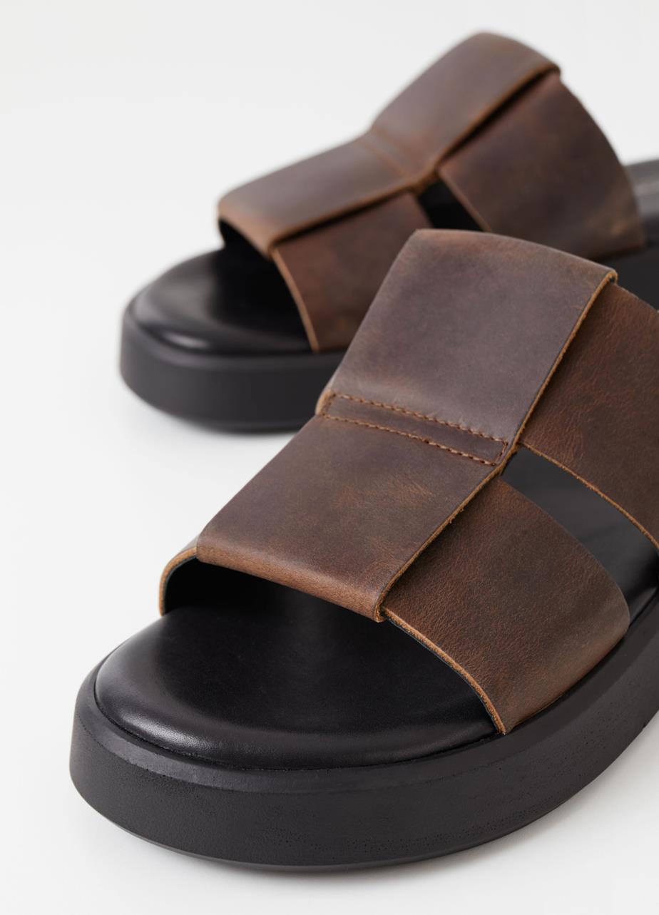 Brown slip-on sandals with woven leather straps in a unique vintage finish.
