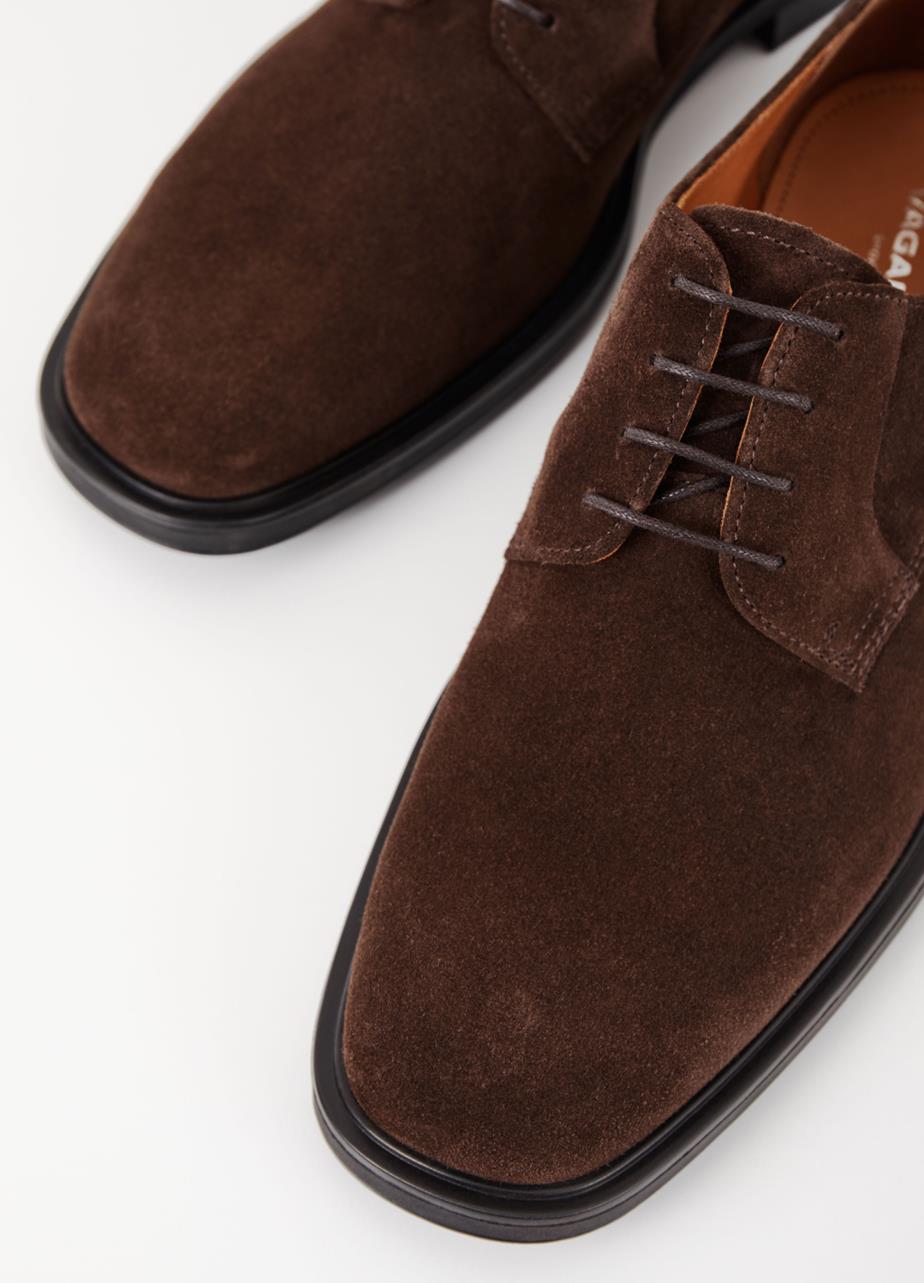 Derby shoes in dark brown suede, designed with monochrome lacing, black outsoles, and stacked heels.