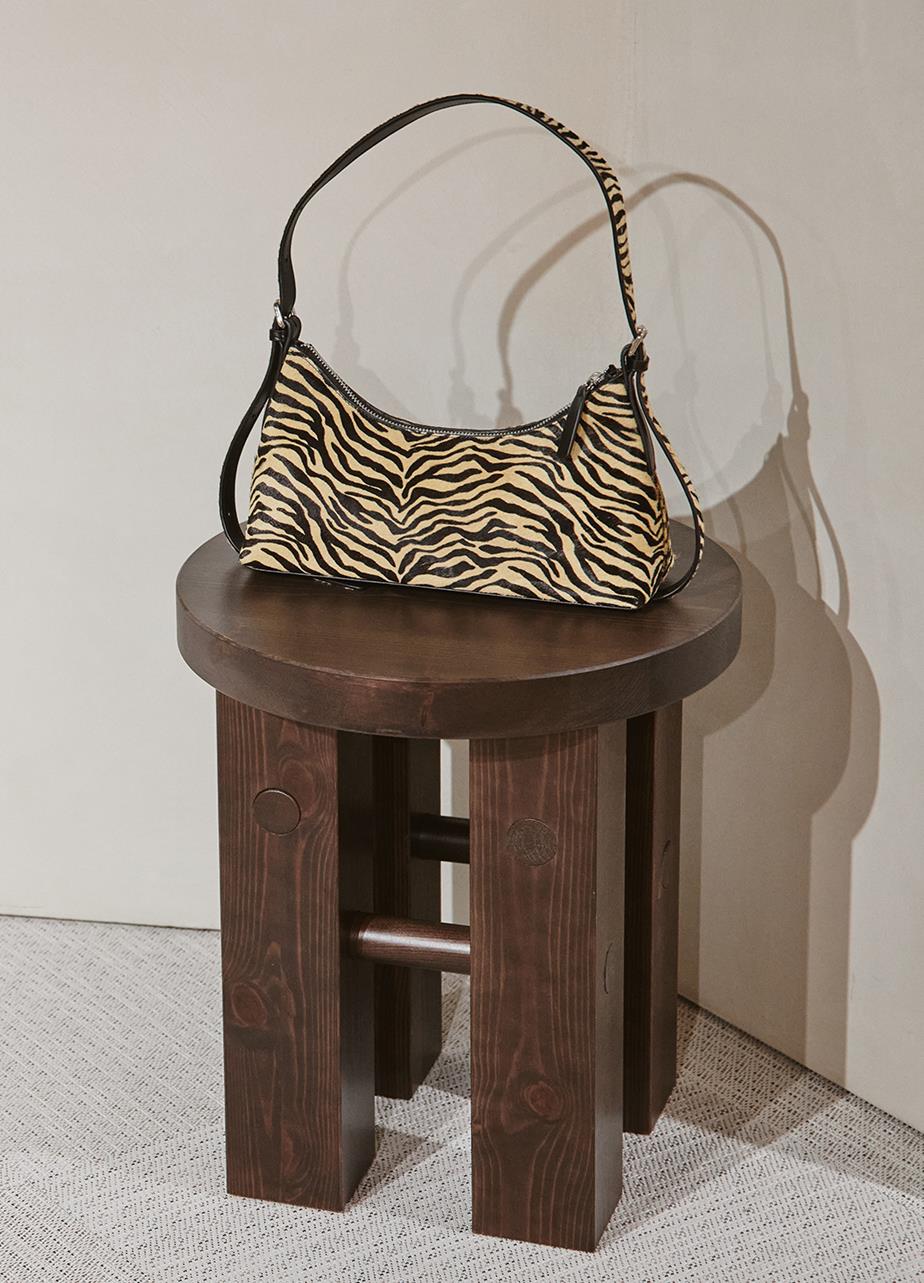 Zebra print purse displayed on a wooden stool at Vagabond pop-up store in Galerie Lafayette