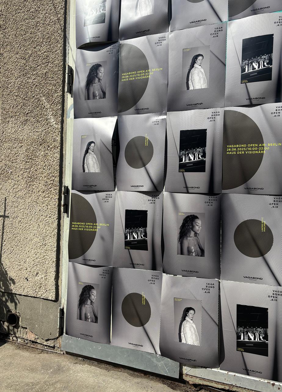 A wall on a building adorned with various "Vagabond Open Air" posters featuring different individuals in black and white with some yellow texts