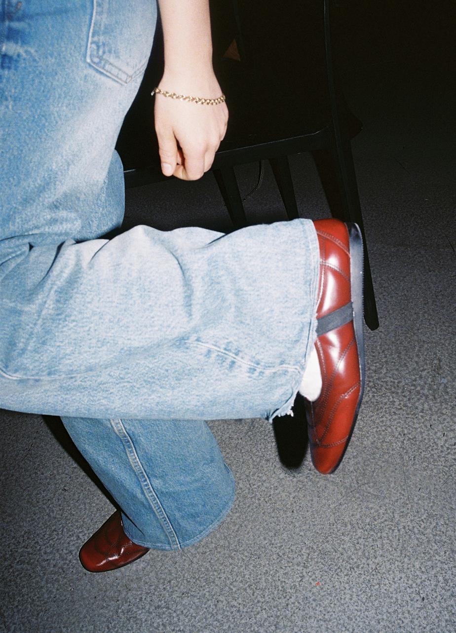 Red Mary Jane flats styled with loose denim.