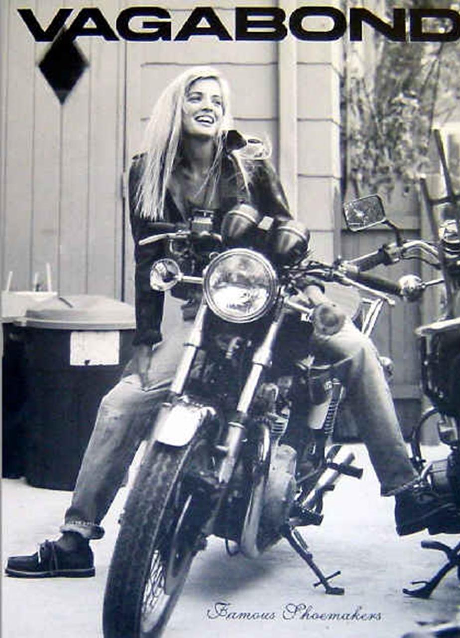Black and white Vagabond ad featuring a woman in a leather jacket and boat shoes on a motorcycle.