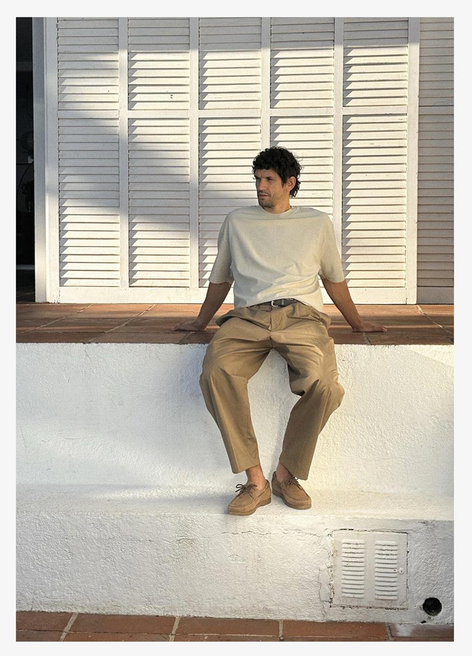 A man is sitting on a wall in the evening sun