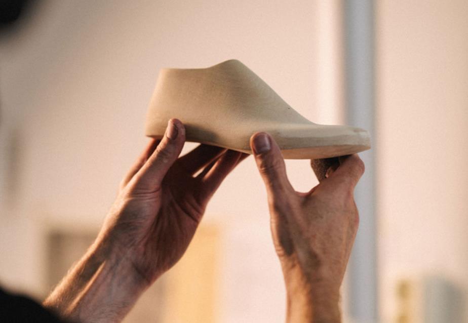 Wooden shoe last held up by two hands