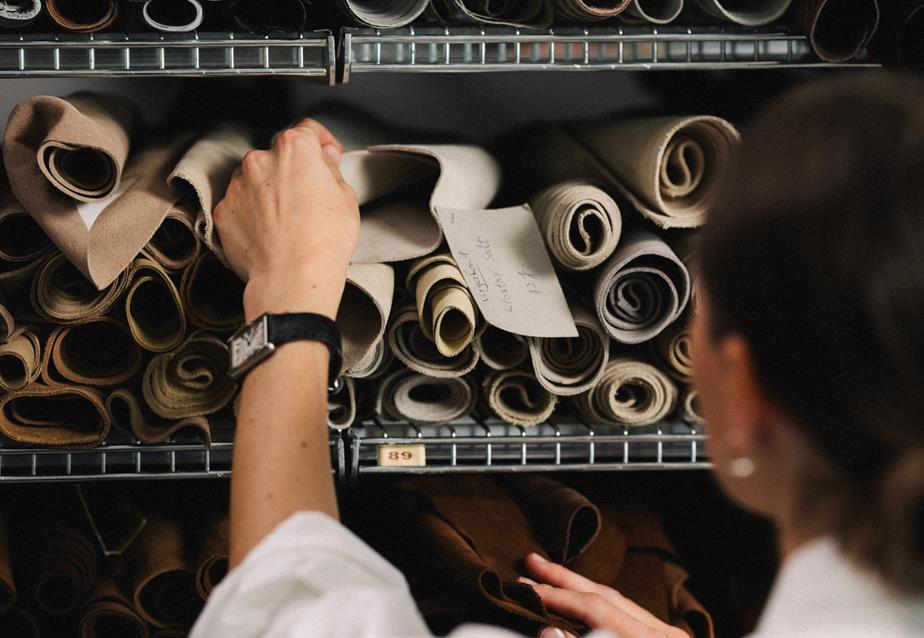 Designer selecting rolls of fabric and leather in a material archive