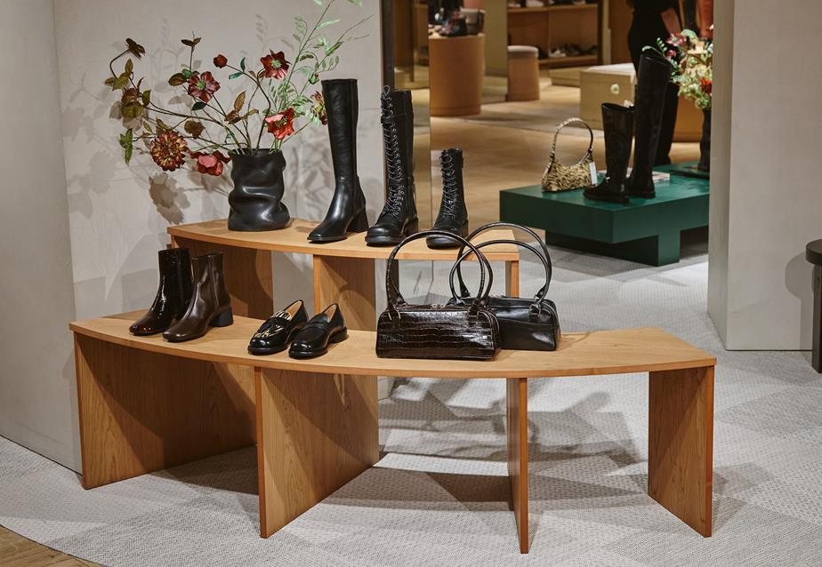 A wooden display featuring Vagabond boots, loafers, and bags at the pop-up store at Galerie Lafayette