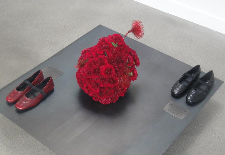 Red Mary Jane shoes on display with a floral centerpiece.